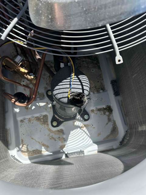 Interior view of an AC unit's compressor, wiring, and contactor area