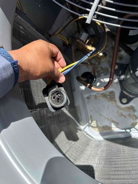 Close-up of a burnt, melted capacitor wire terminal on a Las Vegas AC unit — a common sign this repair is needed