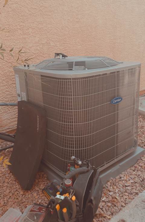 Carrier outdoor AC unit with a technician's tool bag set up for diagnostic and repair work