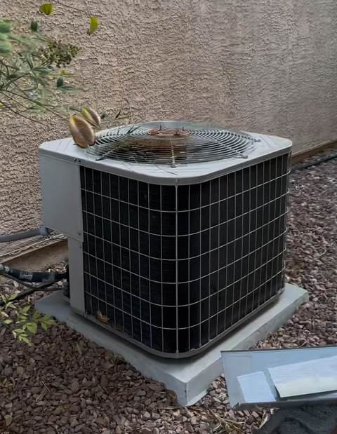 Outdoor AC condenser covered in dust and debris, a common cause of condensate drain line clogs in Las Vegas